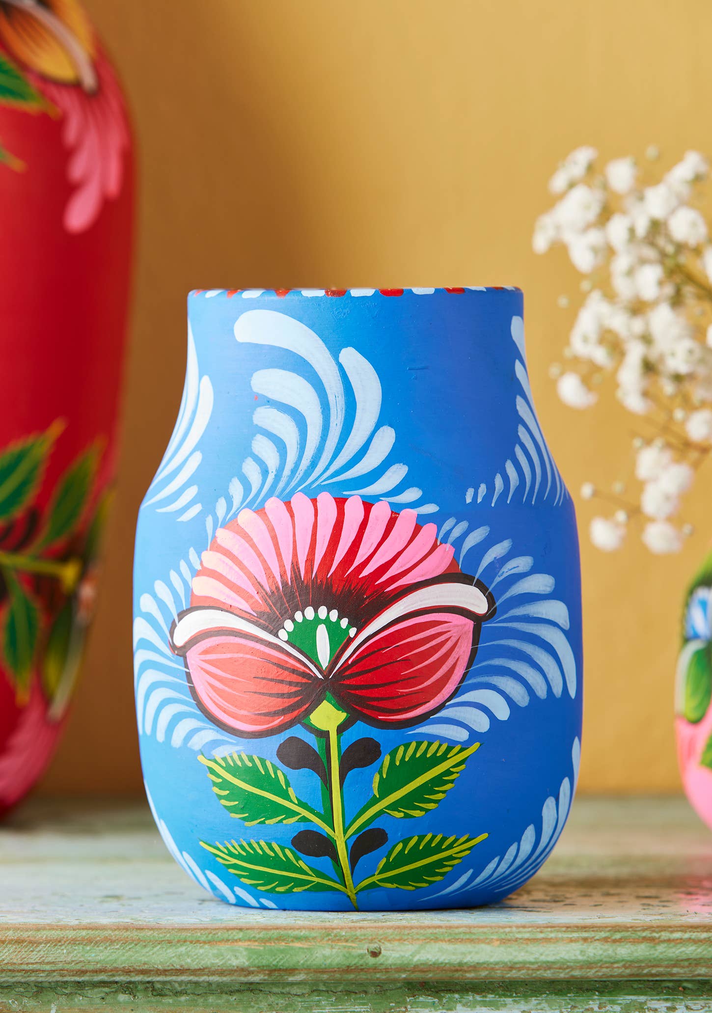 Decorative vase with floral design on a wooden surface