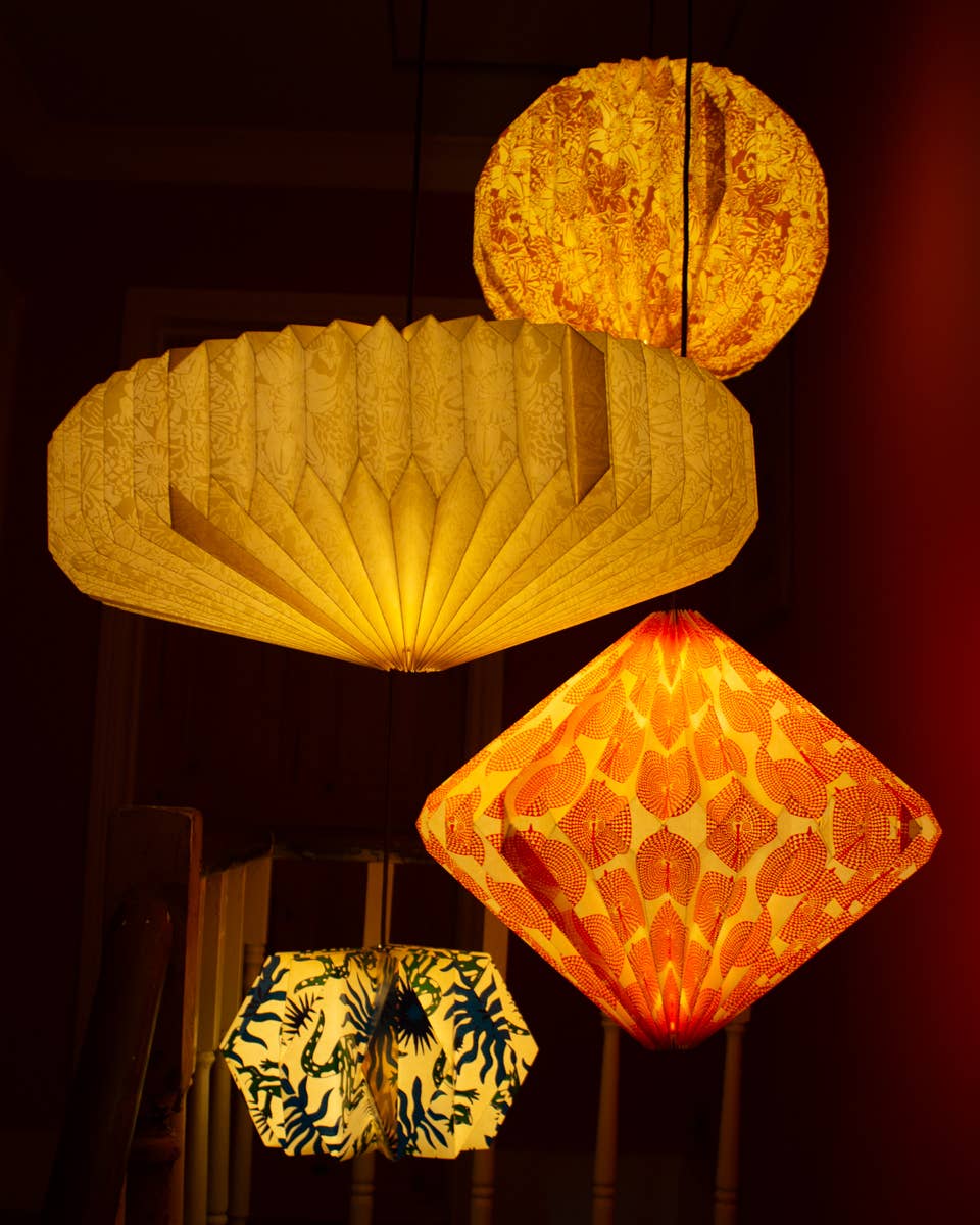 Various paper lanterns with different designs and colors on a dark background