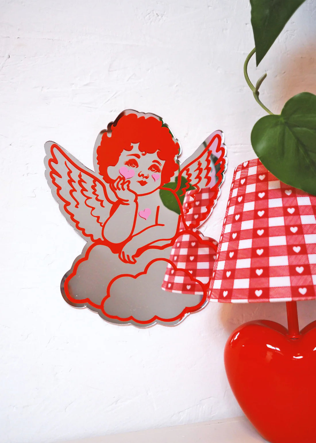 cherub design mirror next to a love heart lamp 