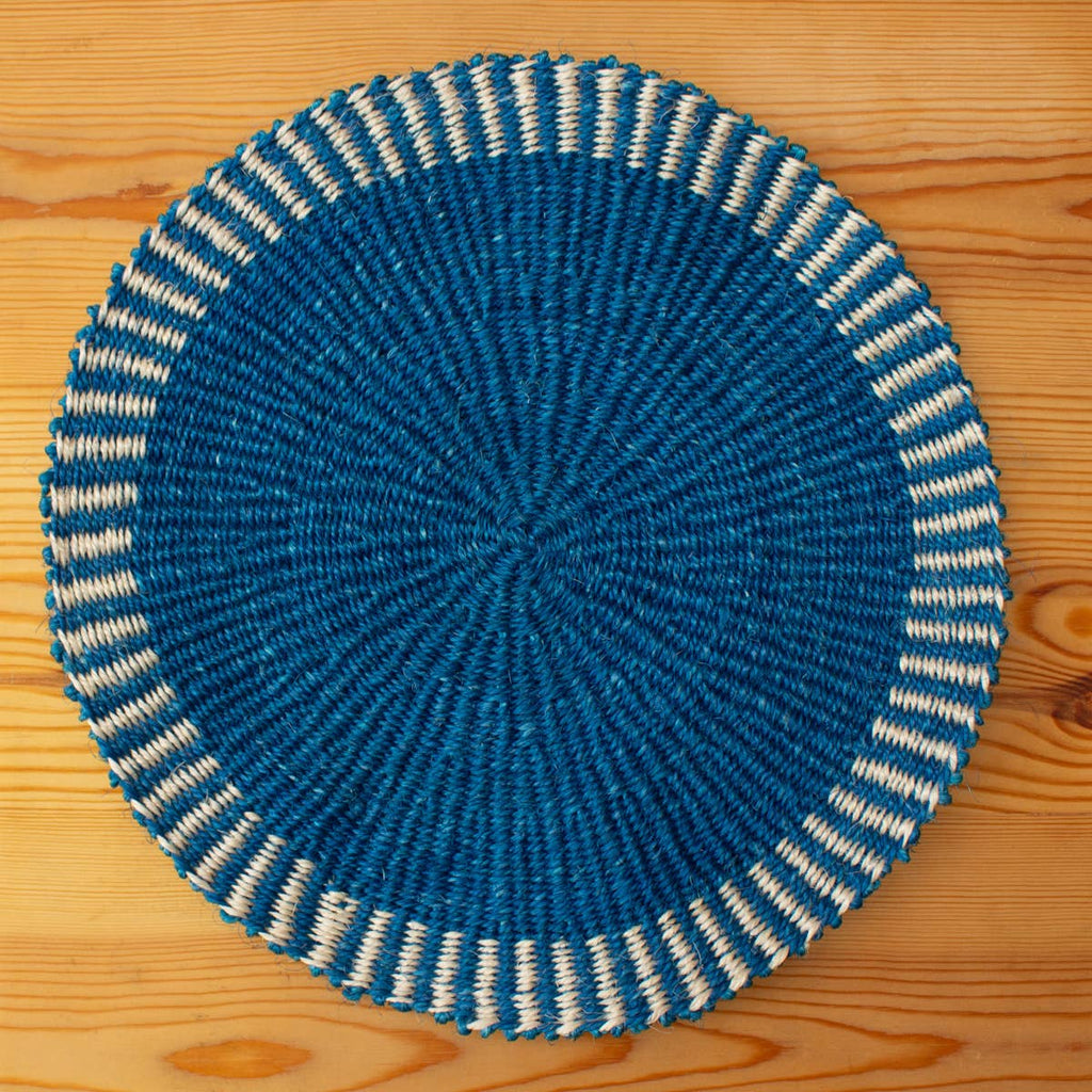 Blue and white woven placemat on a wooden surface