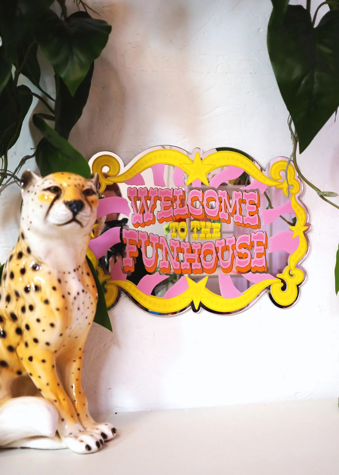 welcome to the fun house printed mirror next toa cheetah 