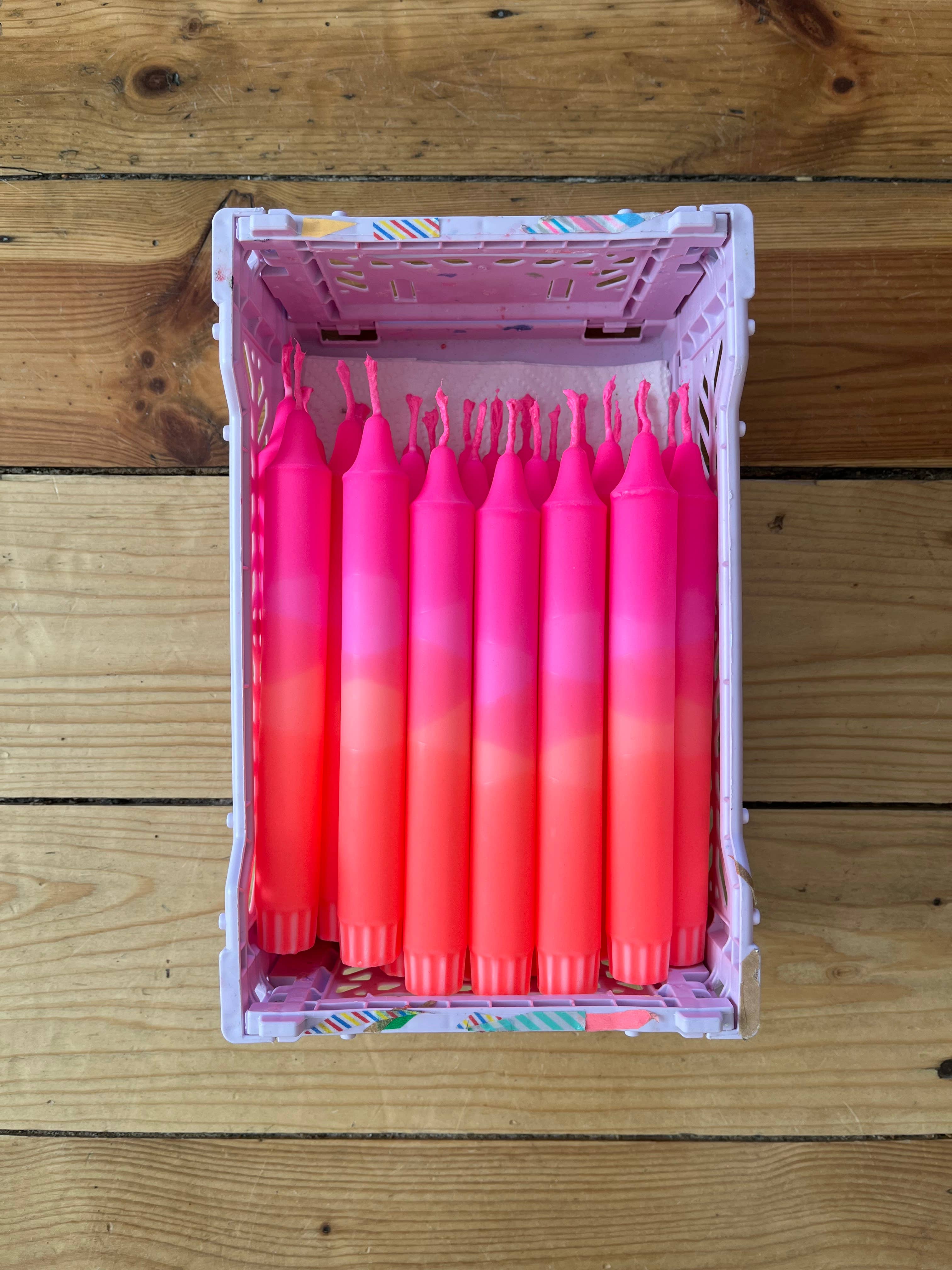Box of pink gradient candles on a wooden surface