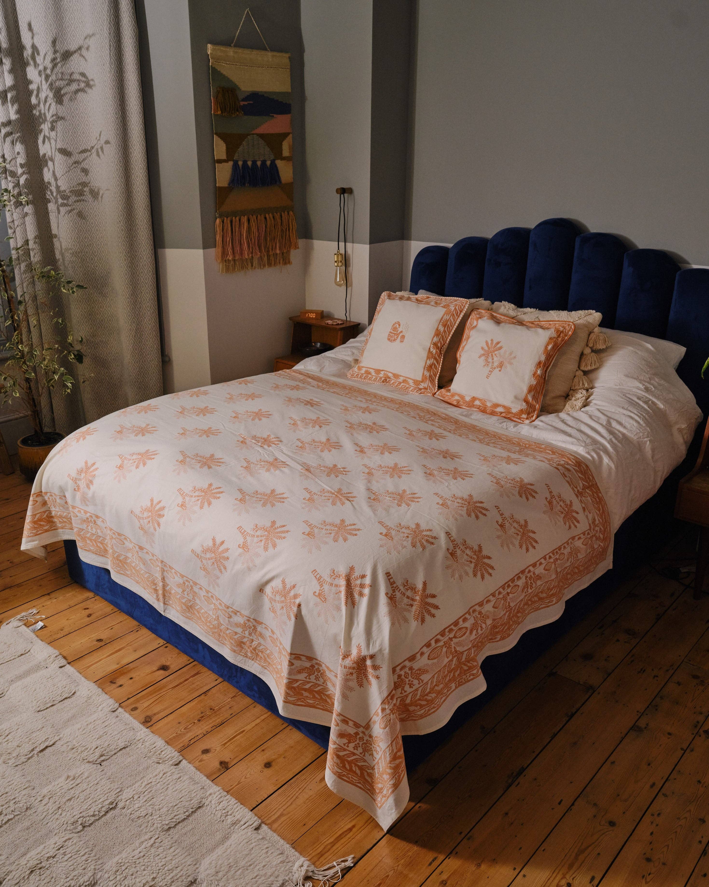 Bedroom with a bed covered in a floral-patterned comforter and pillows.