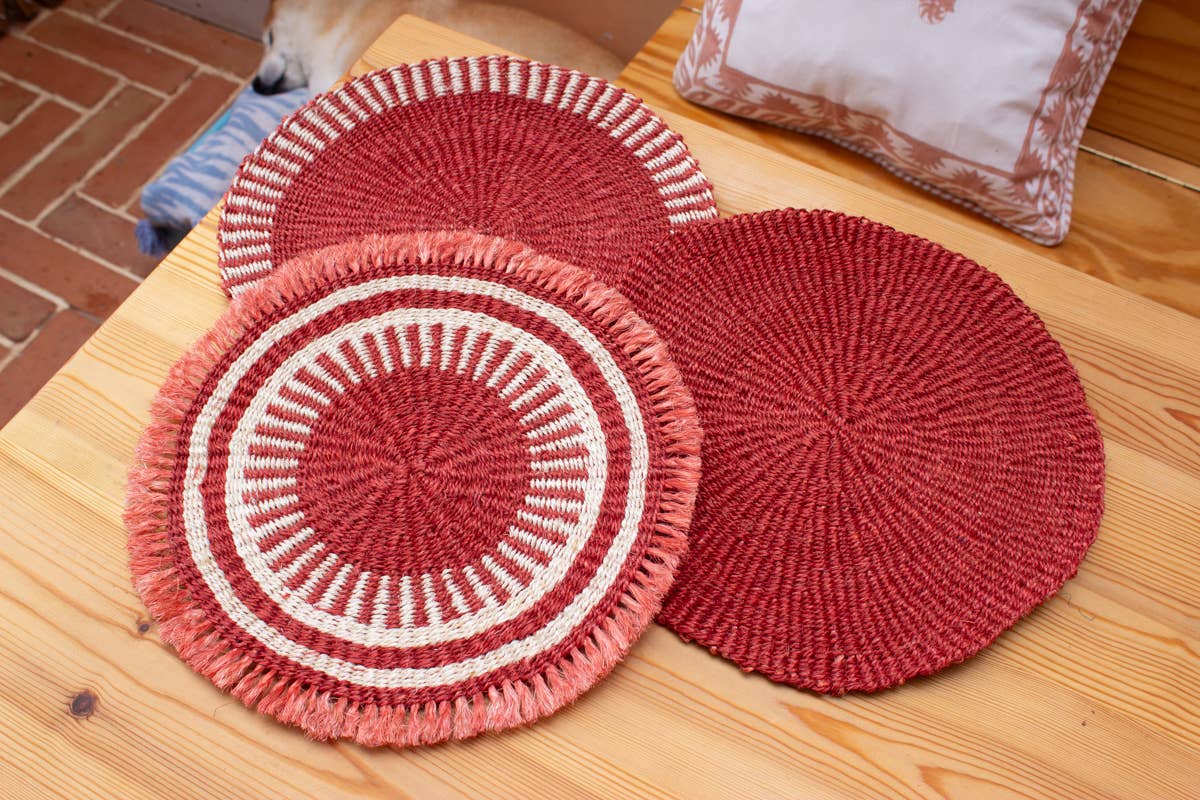 Red and white woven coasters on a wooden surface