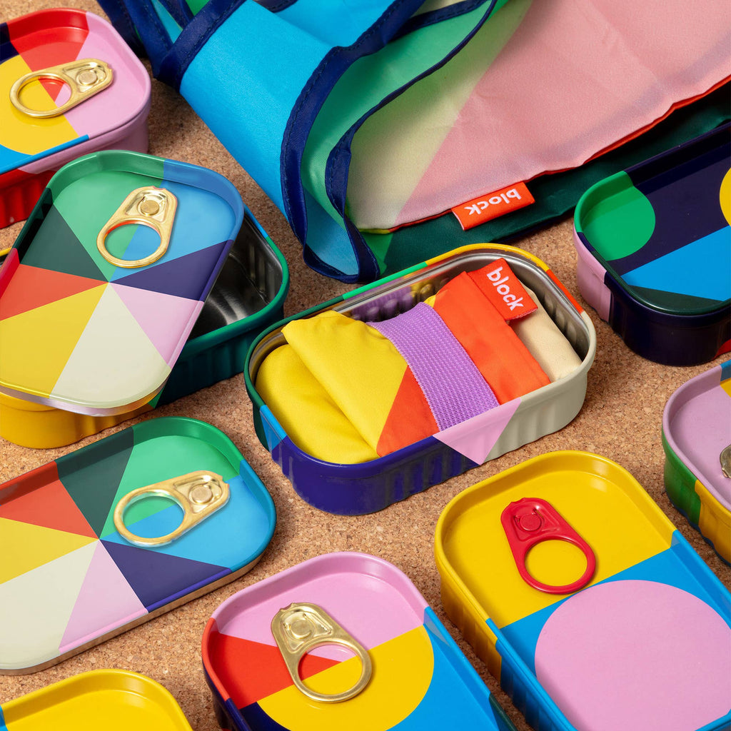 Colorful geometric-patterned tins on a wooden surface