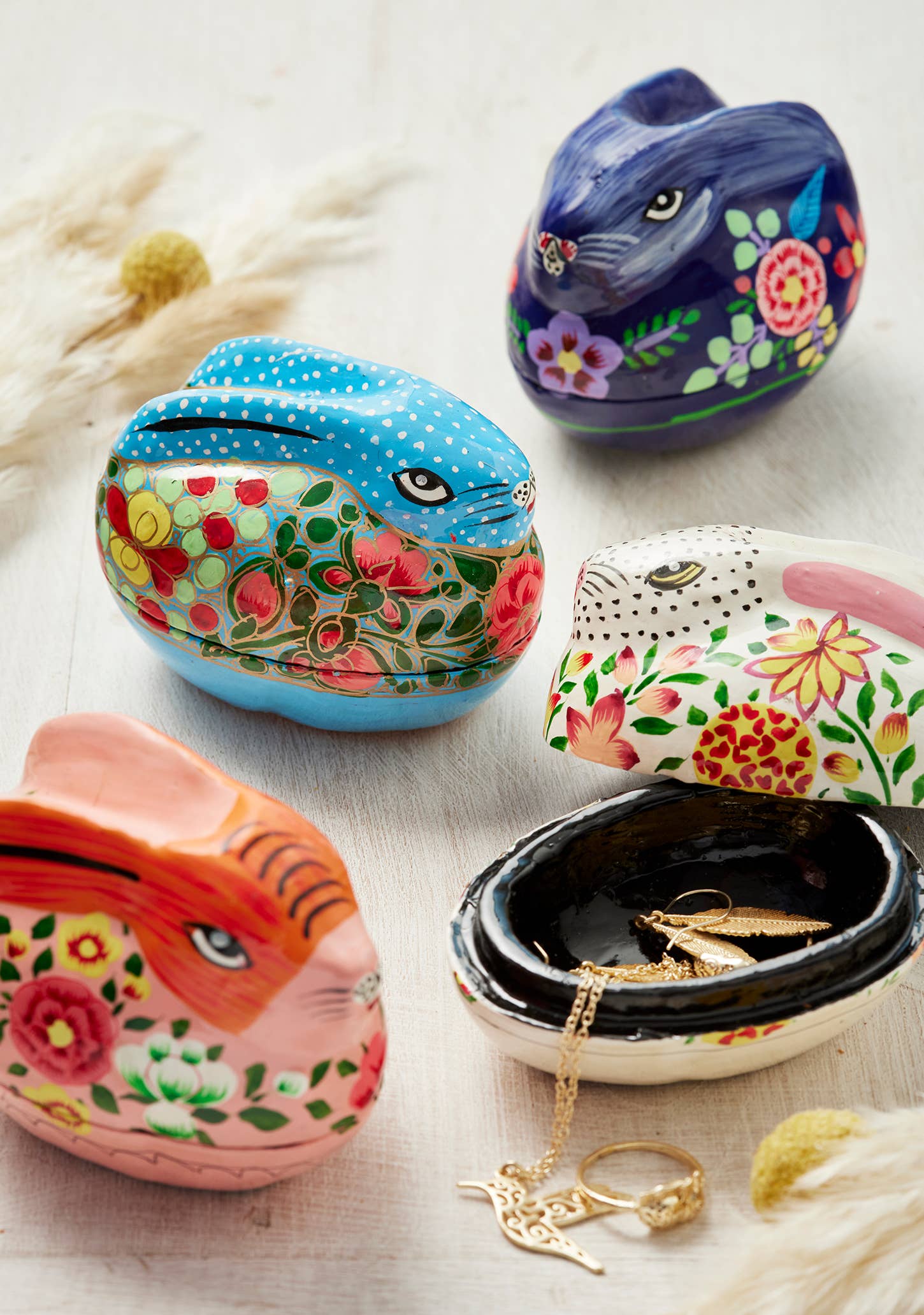 Decorative animal-shaped jewelry boxes with floral patterns on a light background.