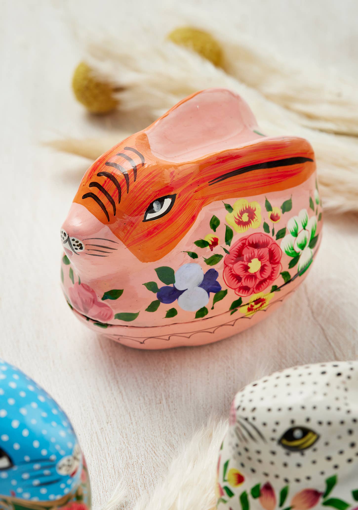 Decorative rabbit-shaped container with floral patterns on a light background