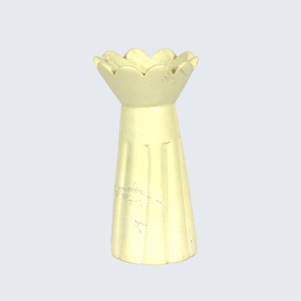 Yellow soapstone  vase with a decorative top on a light gray background