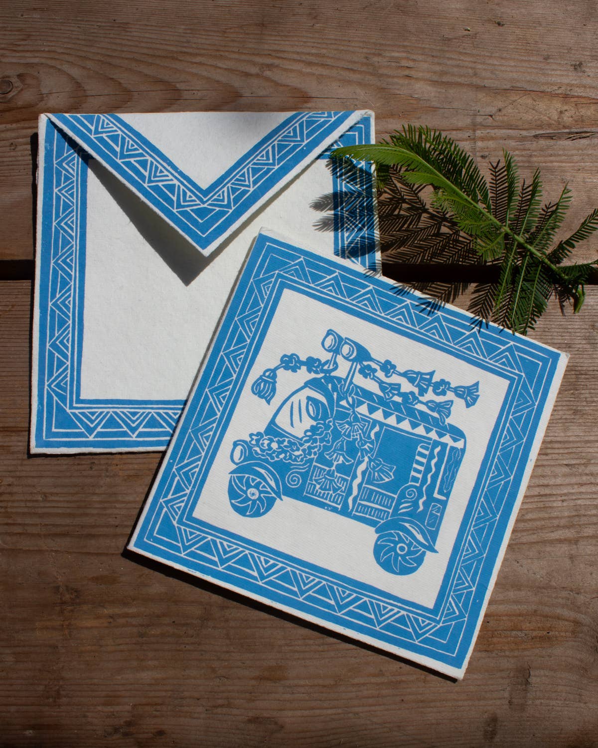 Two blue and white cards with geometric designs on a wooden surface.