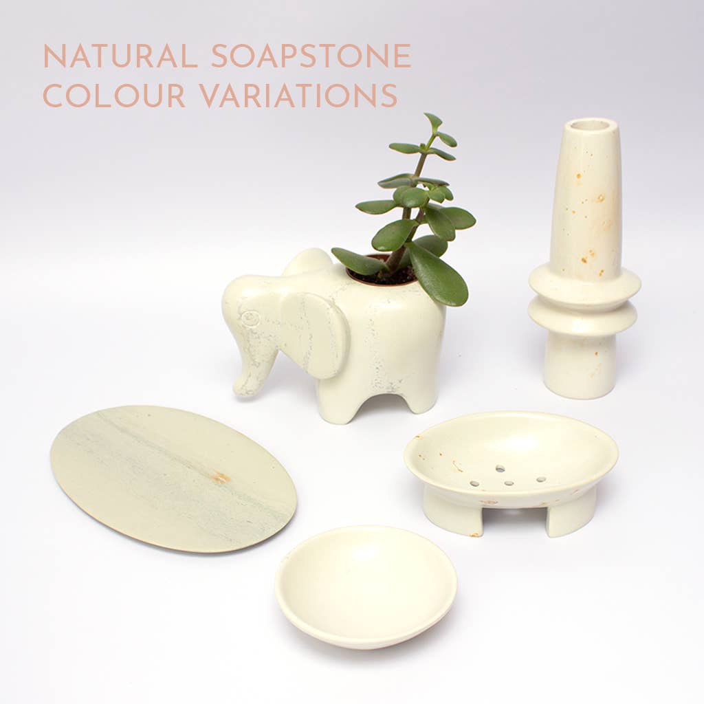 Set of natural soapstone items including a plant holder, candlestick, and small bowls on a white background.