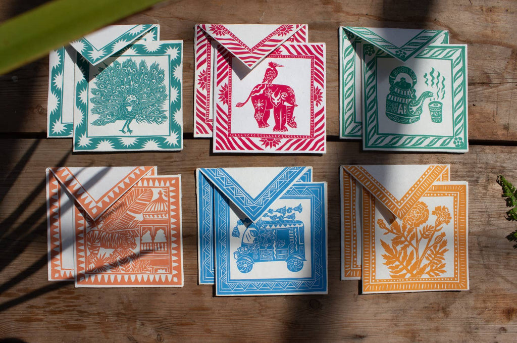 Collection of colorful greeting cards with various designs on a wooden surface