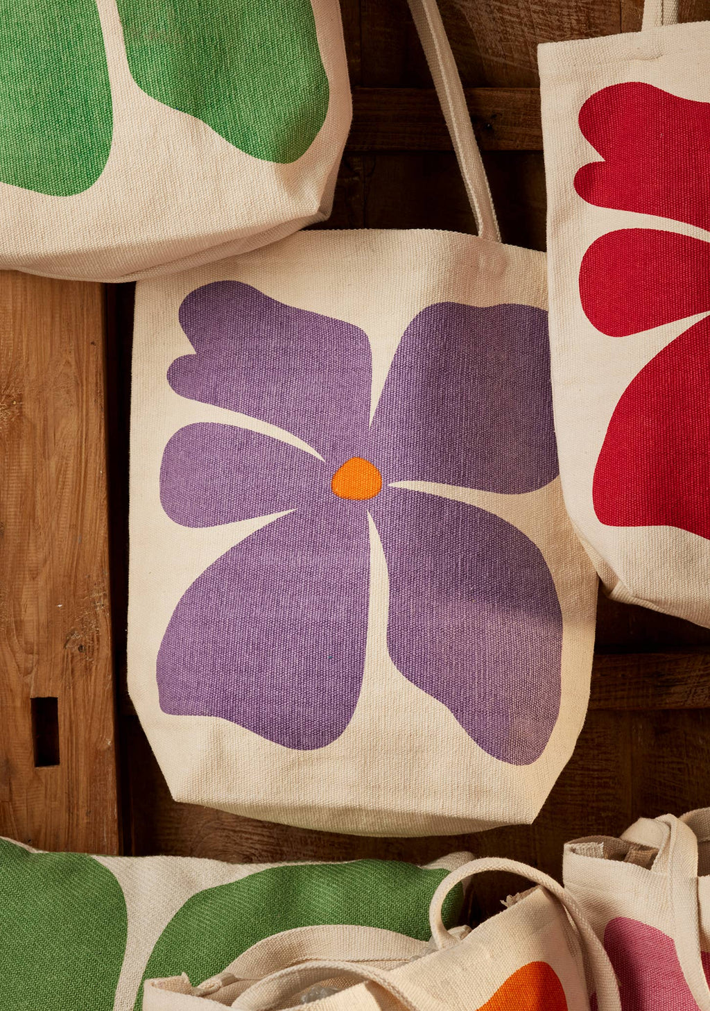 Floral-patterned tote bags on a wooden surface