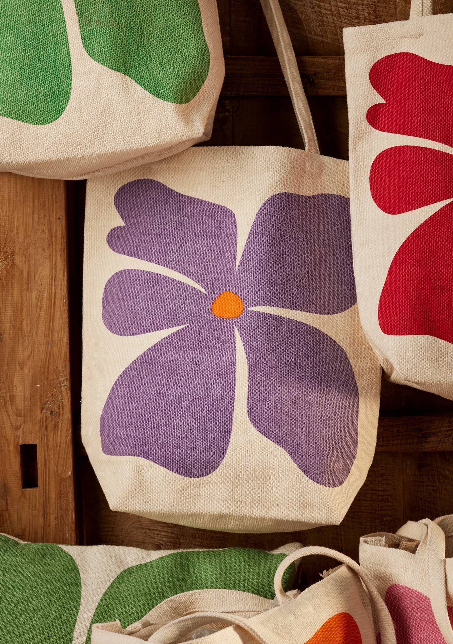 Floral-patterned tote bags on a wooden surface