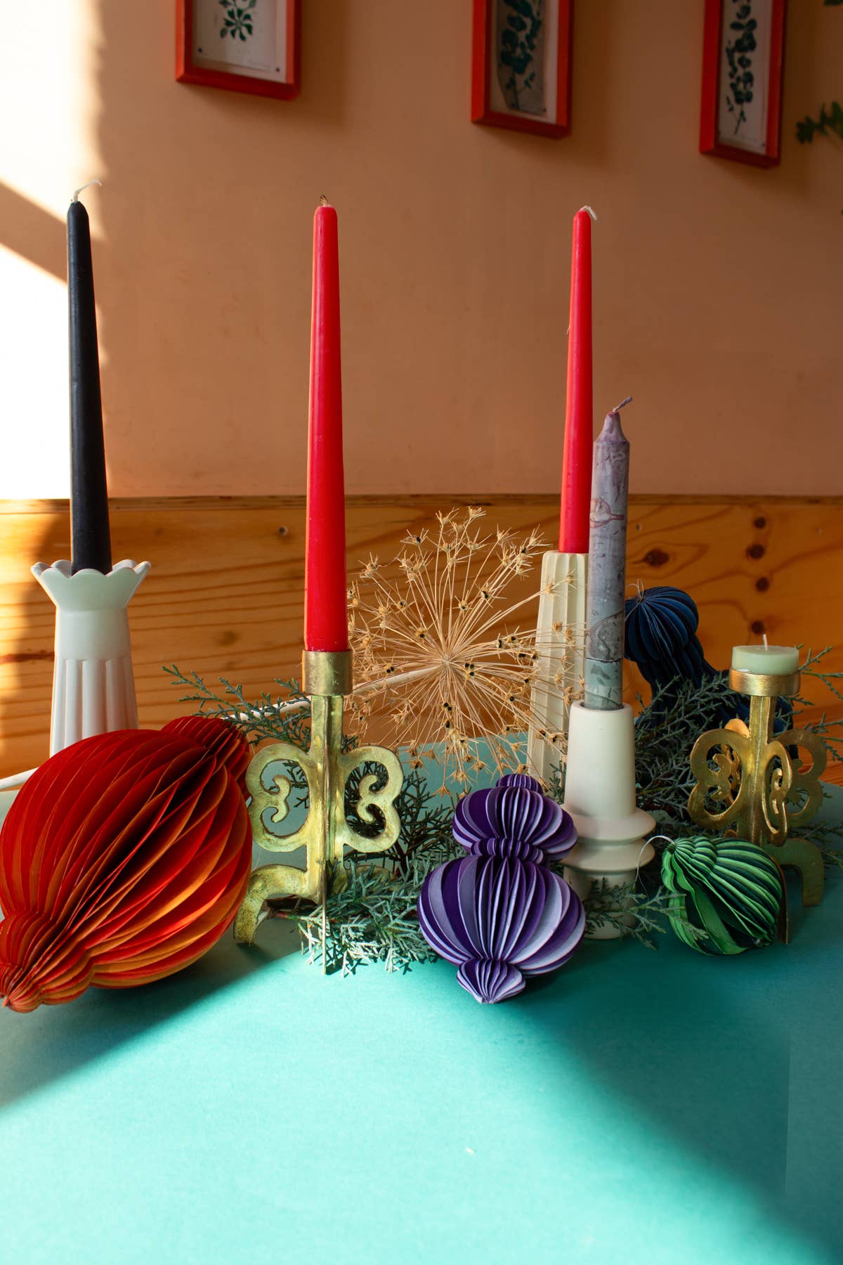 Decorative candles and ornaments on a table with a colorful background