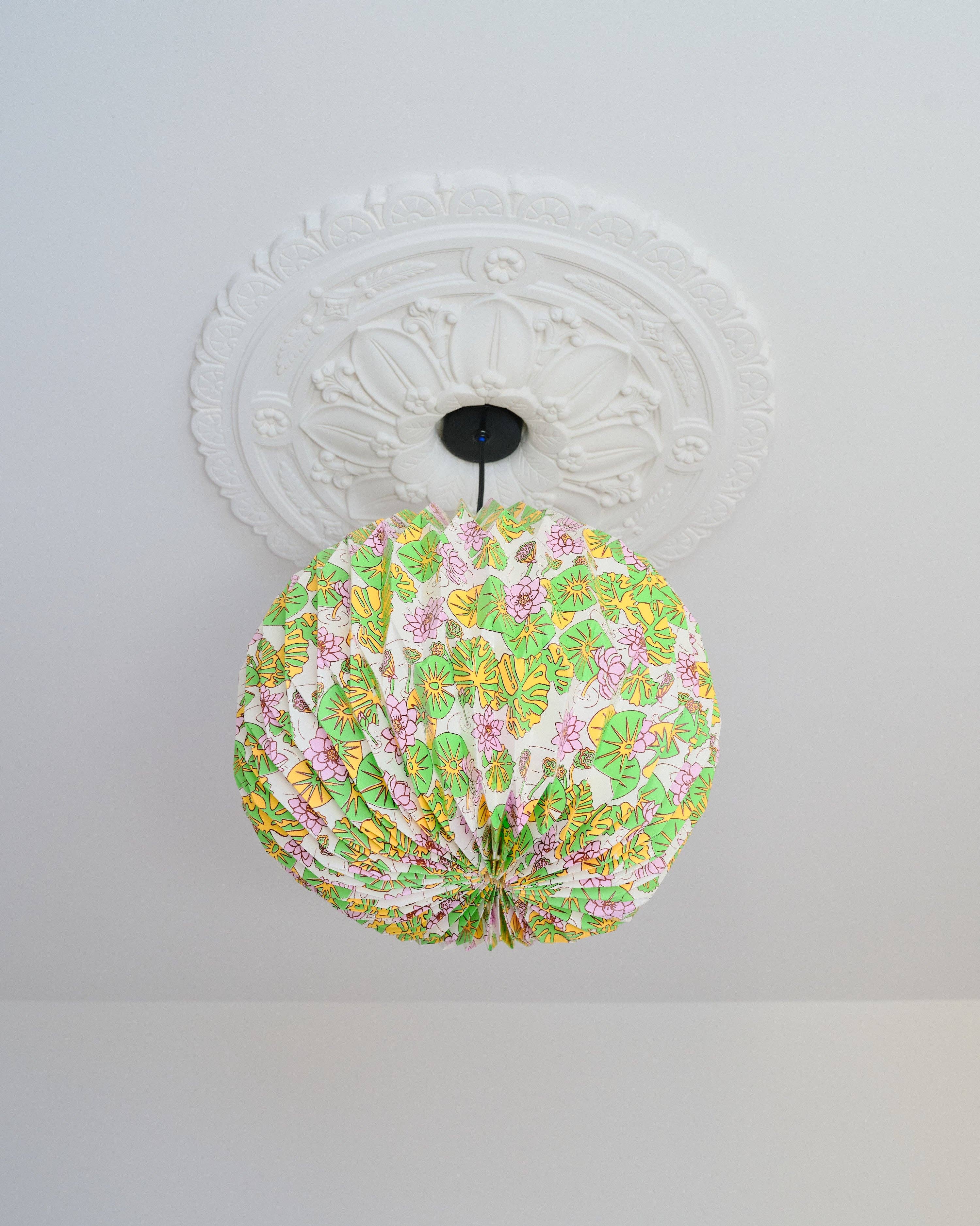 Decorative ceiling light fixture with floral pattern on a white ceiling