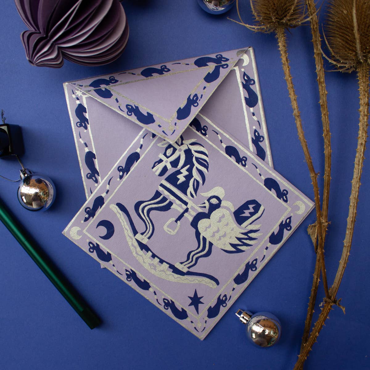 Decorative paper cutouts with a horse design on a blue background