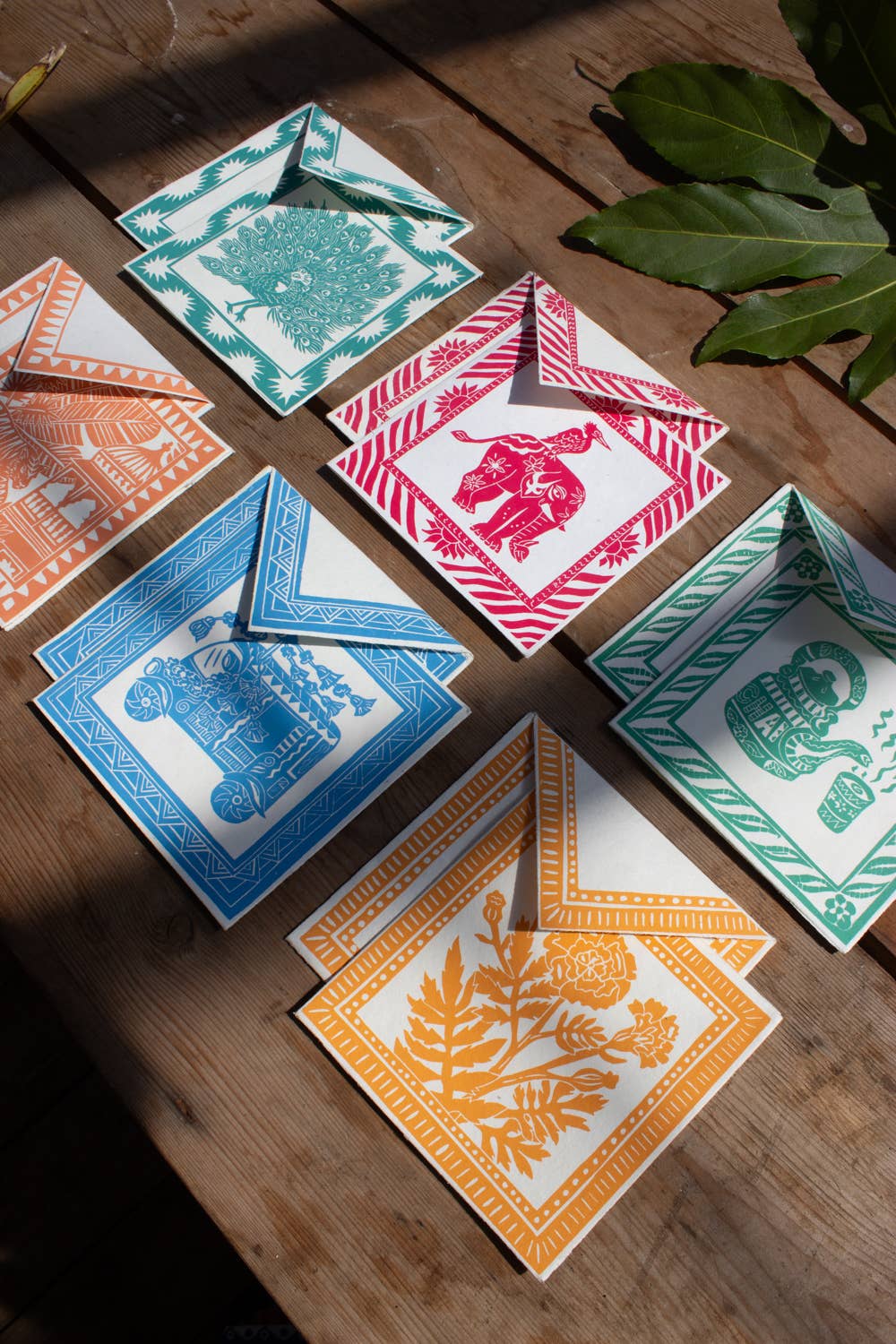 Colorful decorative cards on a wooden surface with leaves in the background