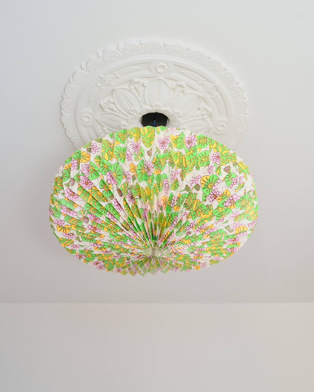 Decorative ceiling light fixture with floral pattern on a white ceiling