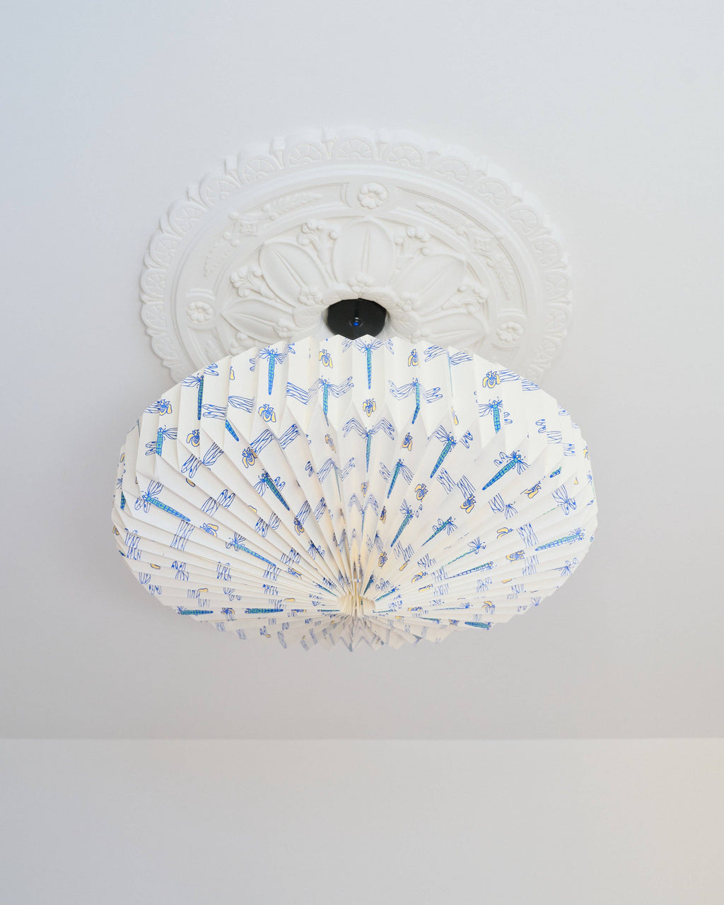 White ceiling light fixture with blue dragonfly design on a white background