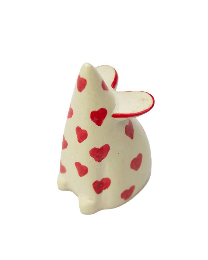 White soapstone mouse with red heart patterns on a white background