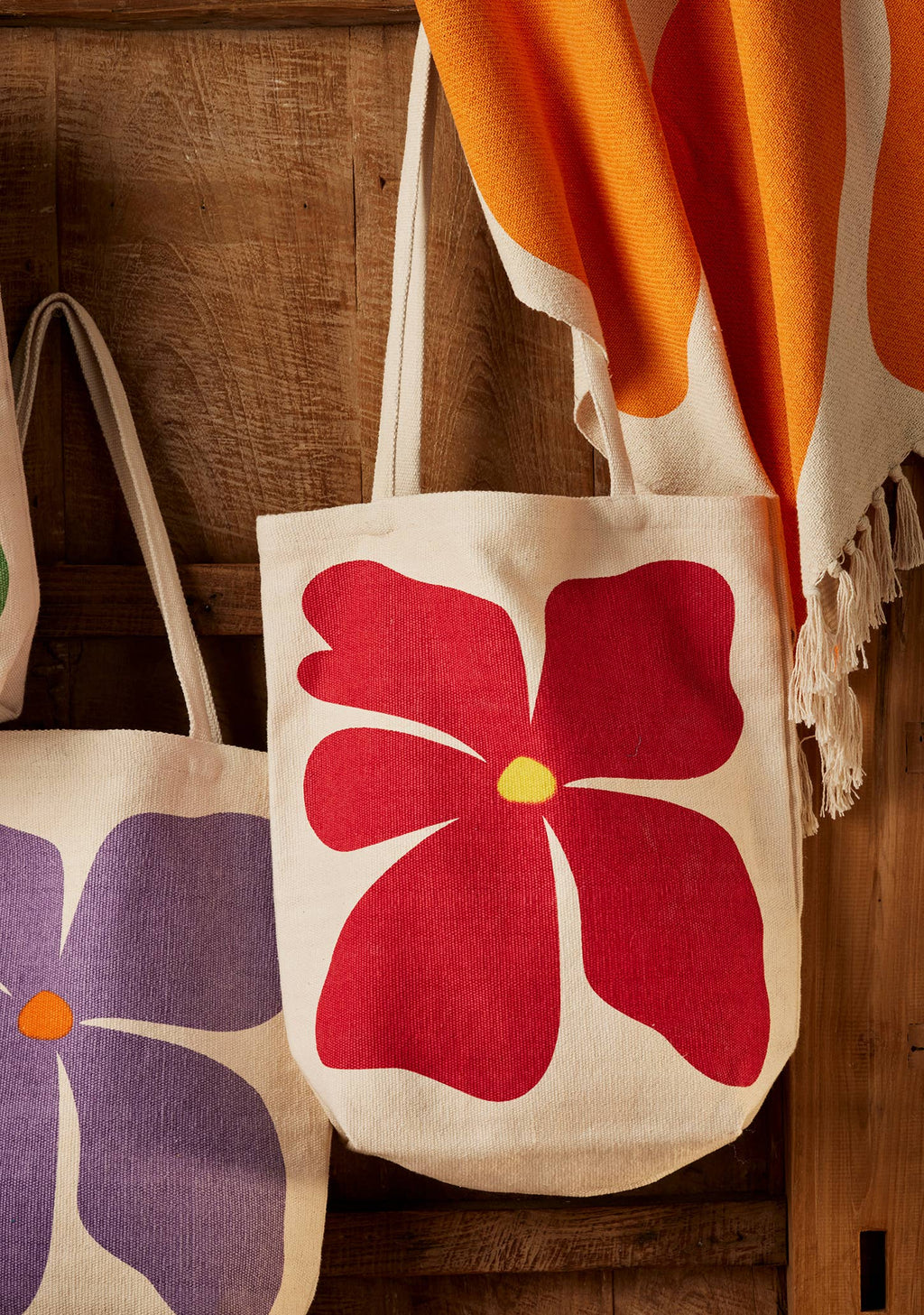 Tote bag with a red floral design on a wooden surface
