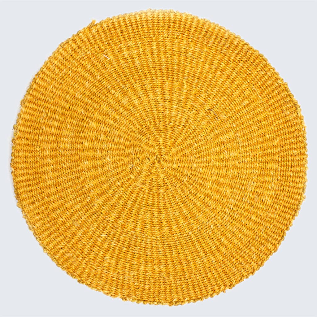 Round yellow woven placemat on a light gray background