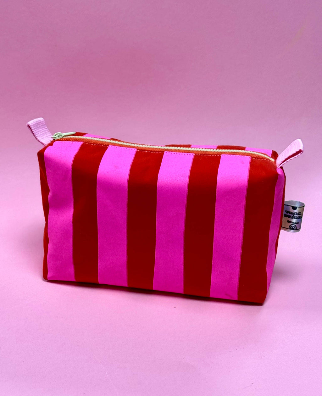 Striped red and pink pouch on a pink background