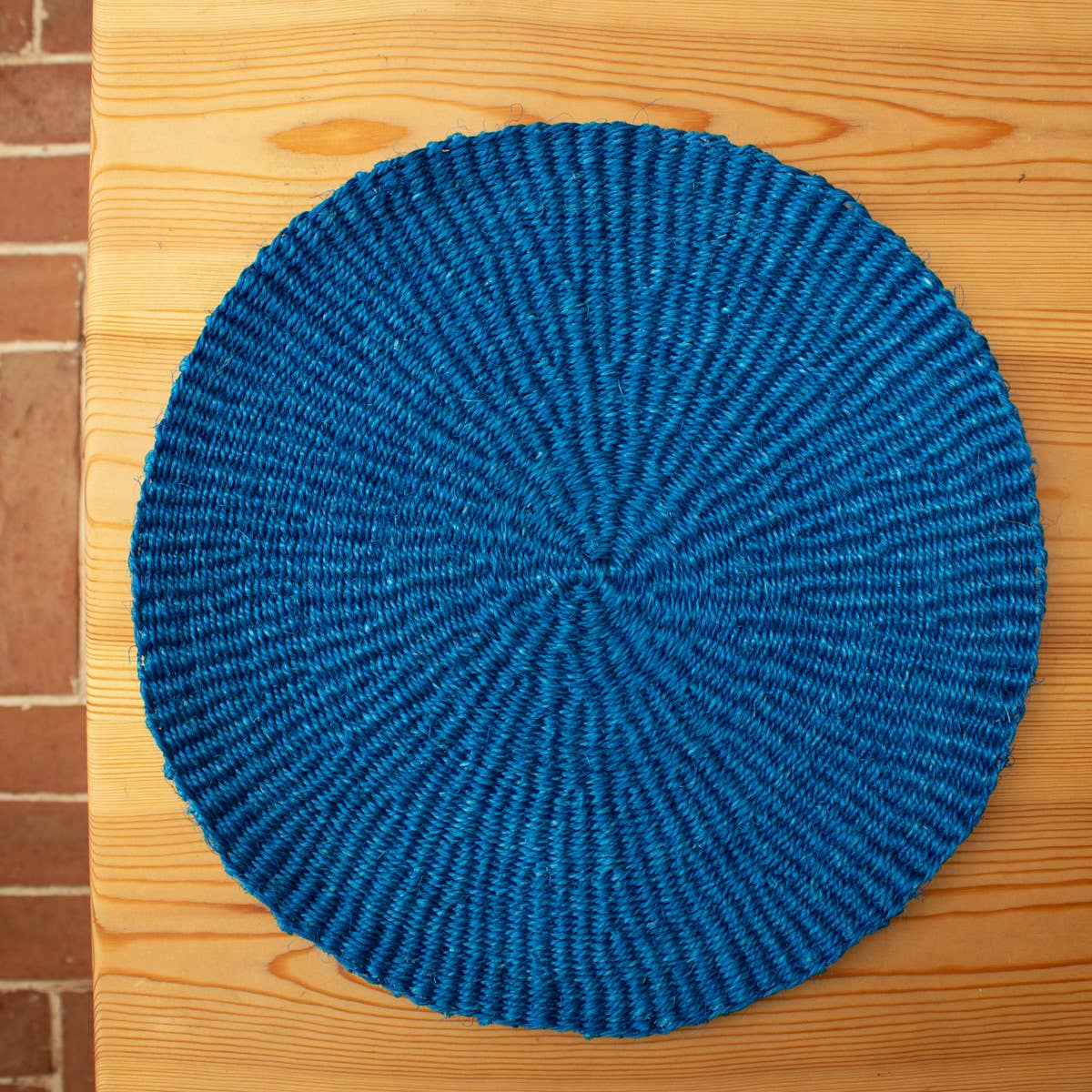 Blue woven mat on a wooden surface