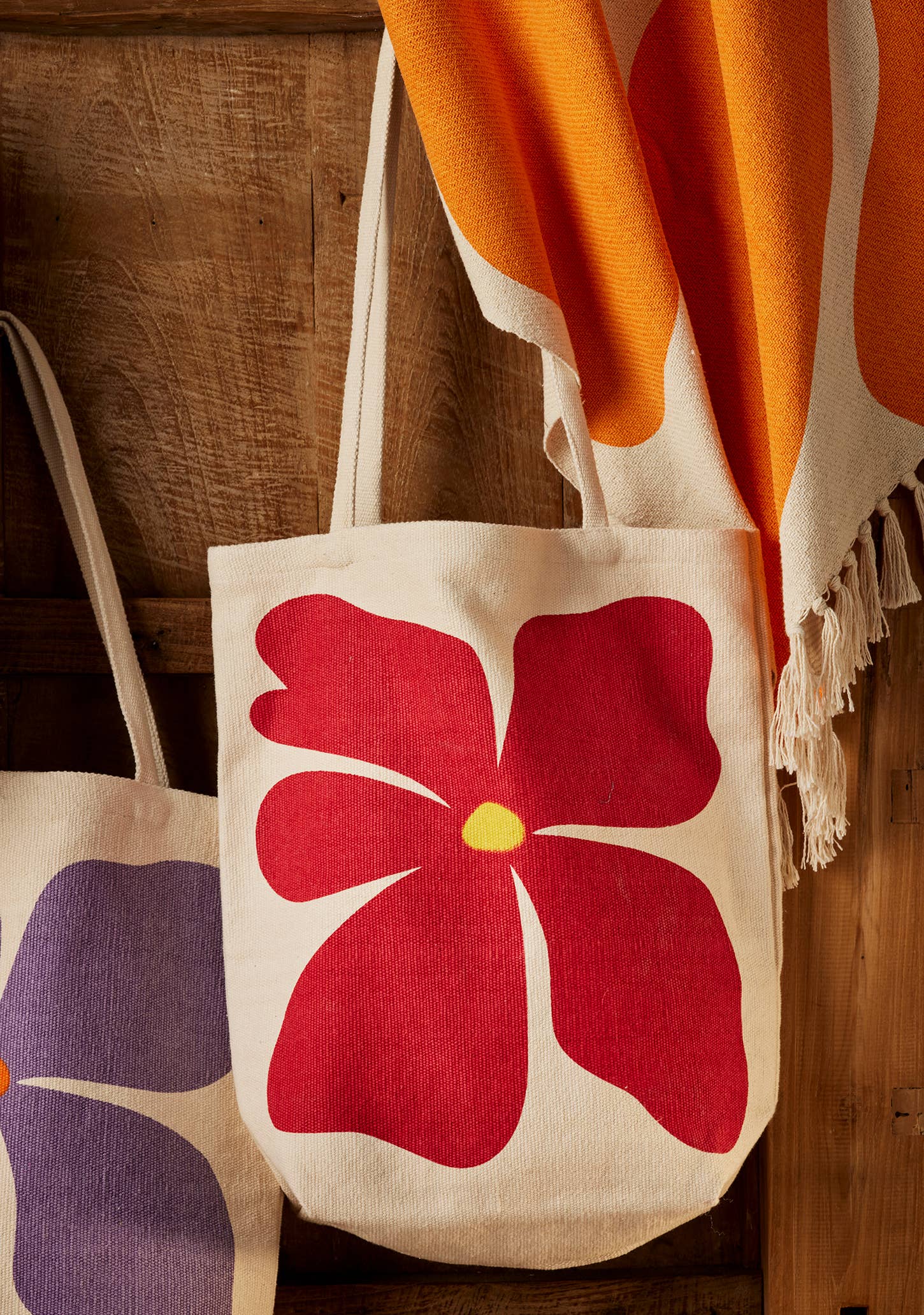 Tote bag with a red floral design on a wooden surface