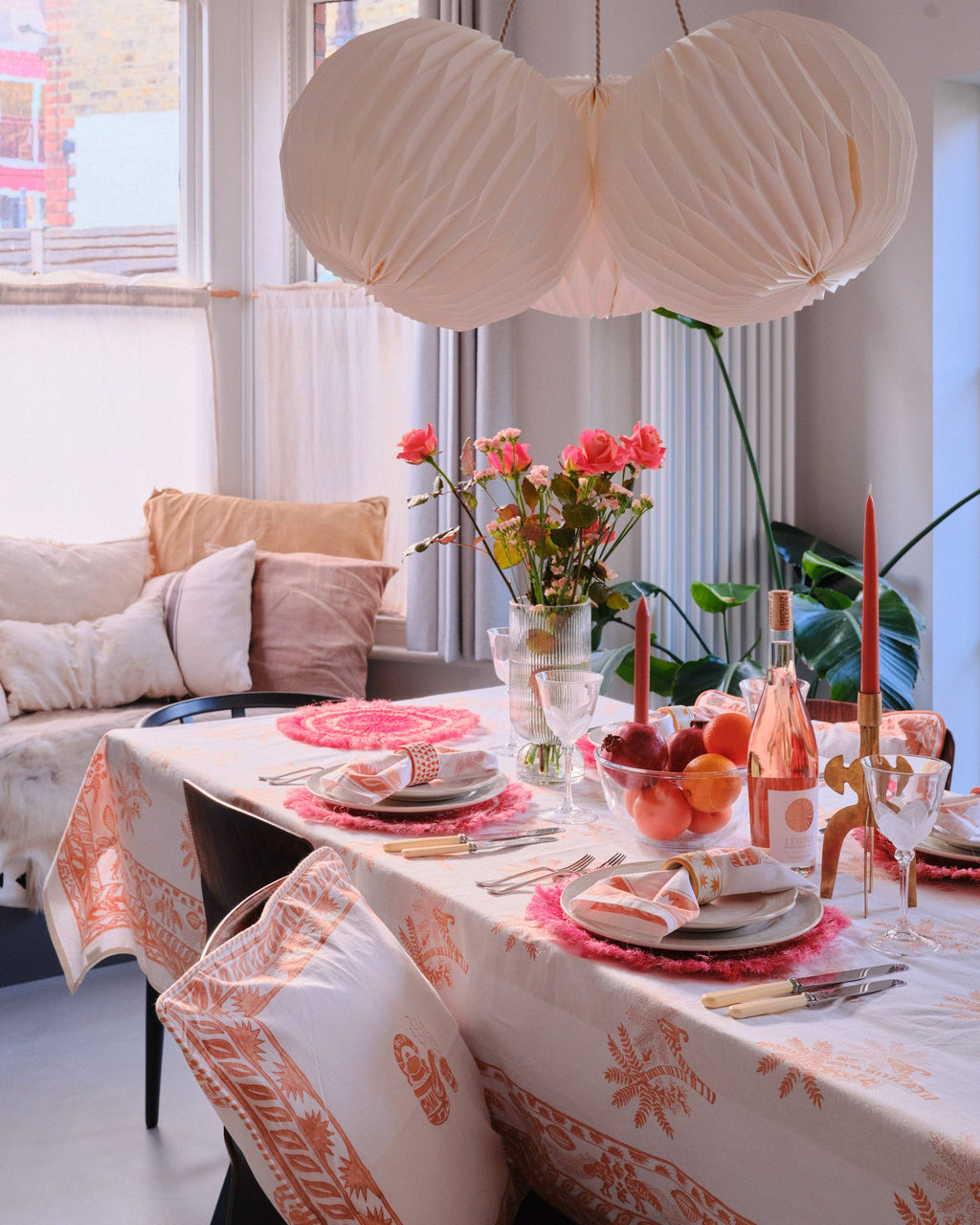 Dining room with a table set for a meal, featuring a floral centerpiece and decorative items.