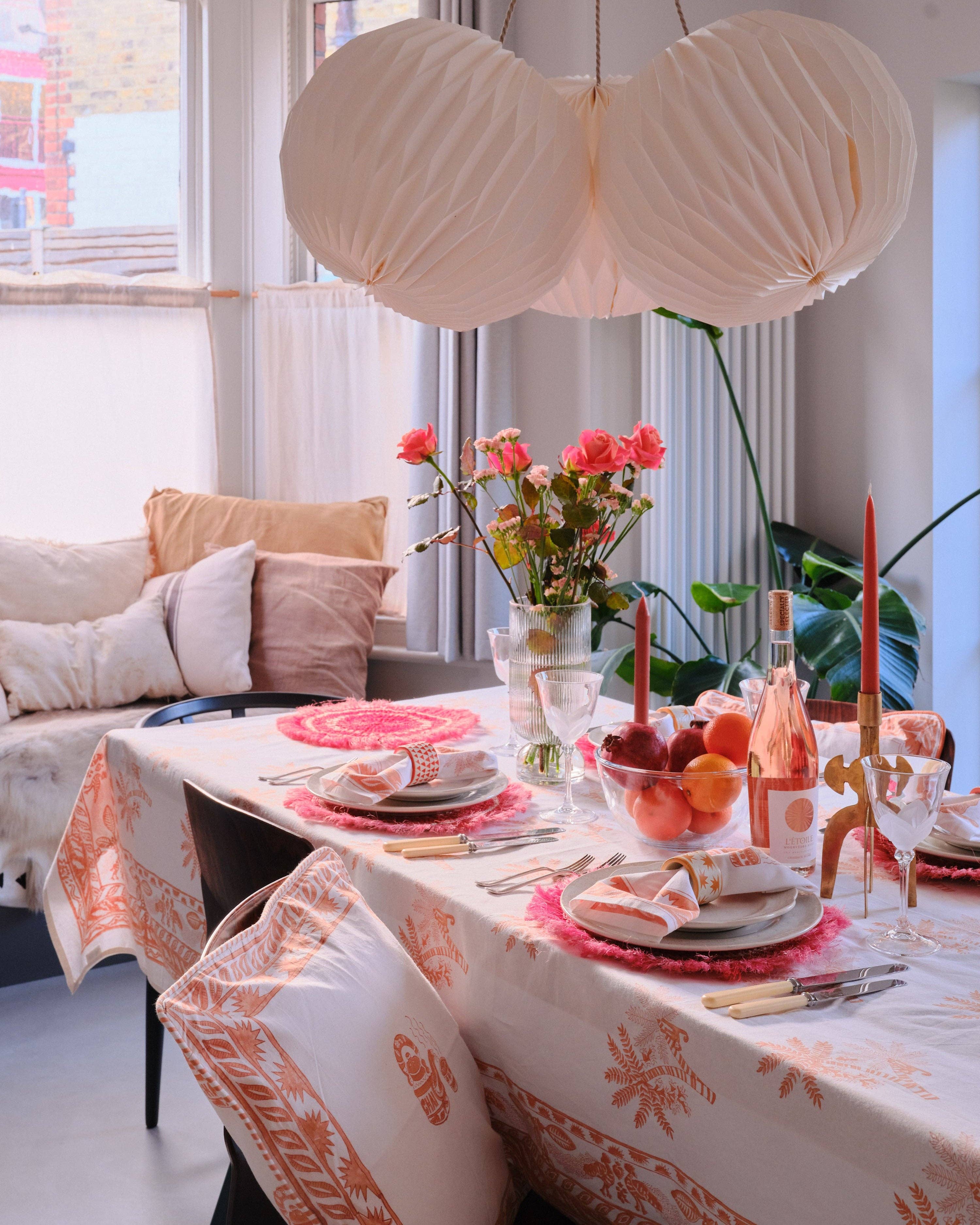 Dining room with a table set for a meal, featuring a floral centerpiece and decorative items.
